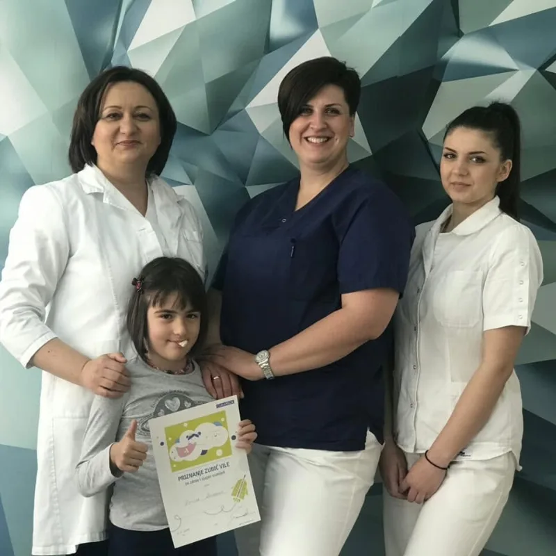 Tim ordinacije Multidental sa djevojčicom koja drži priznanje zubić vile